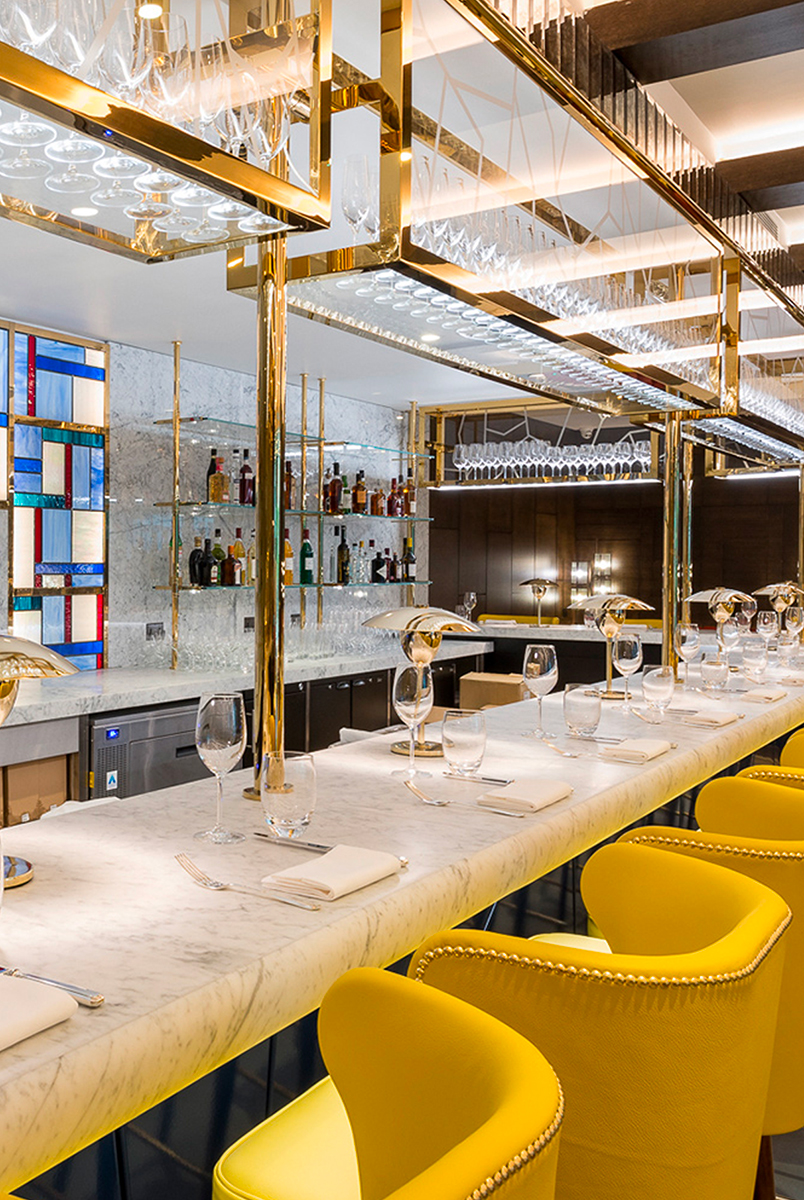 Detail of overhead bar rack in the Brasserie created from V-Grooved PVD stainless steel in Champagne Mirror. The Devonshire Club Hotel, 5 Devonshire Square, London EC2M 4WJ - Interior Design: March & White - PVD coloured stainless steel: Double Stone Steel Europe Ltd