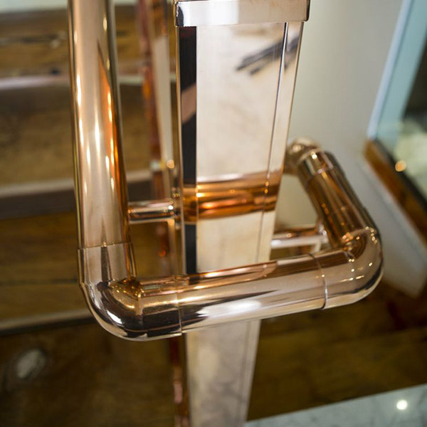 Copper handrail and newel post to staircase by interior designer Katharine Pooley