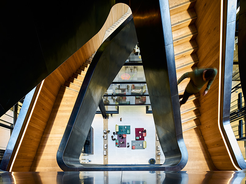 The rough-hewn timber treads – contrasting with the steel very much like the rough interior of a nut with a highly polished shell. Google offices, 6 Pancras Square, London, UK Photography by Tim Soar The rough-hewn timber treads – contrasting with the steel very much like the rough interior of a nut with a highly polished shell. Google offices, 6 Pancras Square, London, UK Photography by Tim Soar