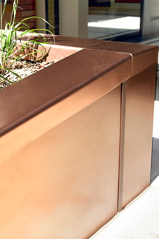 PVD coloured stainless steel in sandblasted Bronze, panel section of planter, Embassy Gardens, London, UK. This image shows how the Bronze has a warm tone in the sunshine. PVD coloured stainless steel in sandblasted Bronze, panel section of planter, Embassy Gardens, London, UK. This image shows how the Bronze has a warm tone in the sunshine.
