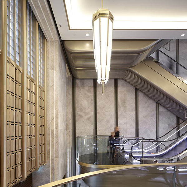 The renovated escalator hall in an Art Deco palette of almond gold, nickel bronze, black and white. Architectural design by Make Architects. PVD coloured stainless steel by Double Stone Steel Europe Ltd. The renovated escalator hall in an Art Deco palette of almond gold, nickel bronze, black and white. Architectural design by Make Architects. PVD coloured stainless steel by Double Stone Steel Europe Ltd.