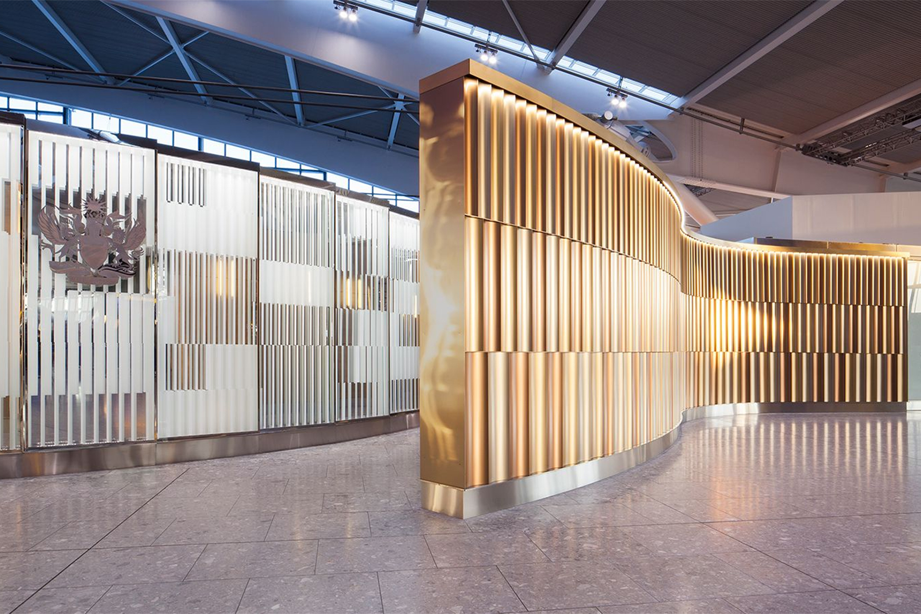 Undulating 3 metre high screen in Chocolate, Champagne and Almond Gold PVD coloured stainless steel creates a Brand Statement for British Airways Private Check-In, Heathrow Terminal 5, London. - Architects/Interior Designers: Universal Design Studio - PVD Coloured Stainless Steel: Double Stone Steel Europe Ltd - Photography: Paul Greenleaf