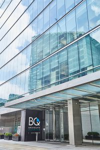 Frameless Glazed Satin Stainless Steel Canopy. 1 Broadgate Quarter, Snowden St, London, EC2A 2AW - Architects: John Robertson Architects. - Stainless Steel Canopy: John Desmond Ltd - Showing the new canopy design integrated into the original façade.