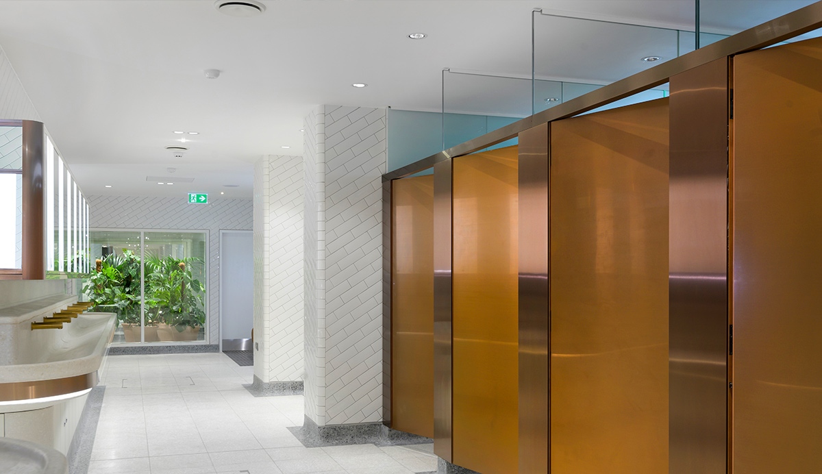 Interior of upgraded toilets at Victoria Station, London. - Showing contrast in cubicle door and surround achieved through turning the grain of the stainless steel 45 degrees. PVD coloured stainless steel in Rose Gold Hairline. - Client: Network Rail - Architects: Landolt + Brown - Fitout: Maxwood Washrooms - PVD coloured stainless steel by Double Stone Steel - Architectural metalwork by Double Stone Steel Europe Ltd Interior of upgraded toilets at Victoria Station, London. - Showing contrast in cubicle door and surround achieved through turning the grain of the stainless steel 45 degrees. PVD coloured stainless steel in Rose Gold Hairline. - Client: Network Rail - Architects: Landolt + Brown - Fitout: Maxwood Washrooms - PVD coloured stainless steel by Double Stone Steel - Architectural metalwork by Double Stone Steel Europe Ltd
