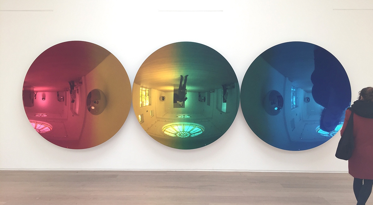 In Anish Kapoor’s Red to Blue (2016) stainless steel discs reflect distorted and inverted images of visitors as they move through the colour spectrum. Photograph by Stefan Tribe