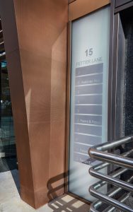 Tapered column in PVD coloured stainless steel, Chocolate, V-Grooved and folded to appear as solid bronze. - Office building, 15 Fetter Lane, EC4A, London. - Architects: McBains Cooper - Client: British Steel Pension Fund Trustees Ltd - Fit-out: Nucom Interiors - Canopy, column and Brise Soleil fabricated in PVD coloured stainless steel and installed by John Desmond Ltd.
