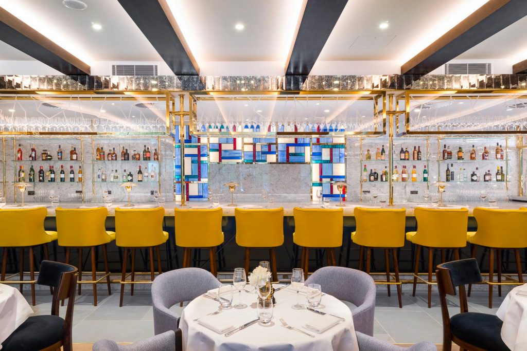 The Brasserie bar in the Devonshire Club Hotel with overhead glass rack in brass PVD coloured stainless steel.The Devonshire Club Hotel, Interior Design: March & White, PVD coloured stainless steel: Double Stone Steel Europe Ltd